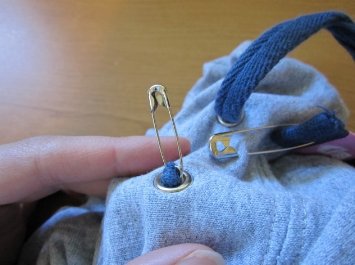 6. If instead, you want to pull out the end of the cord on your hoodie, try this trick using safety pins.