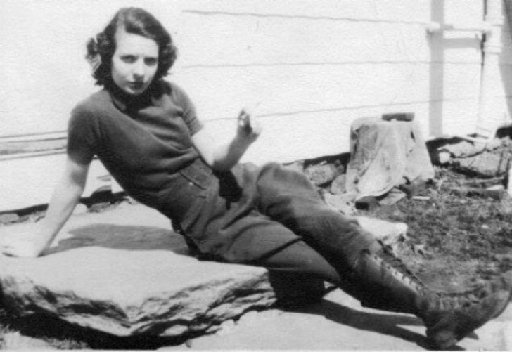 My grandma as she smokes a cigarette on a farm. She was already wearing pants and doing whatever came into her head!