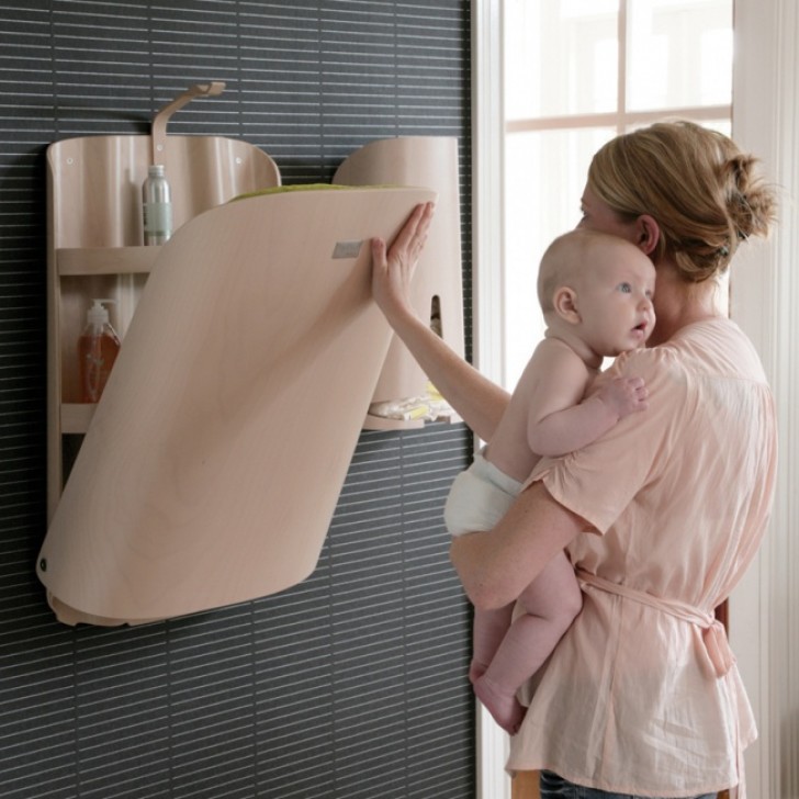 20. Wall mounted baby changing table with all the necessary items for taking care of a baby within easy reach.