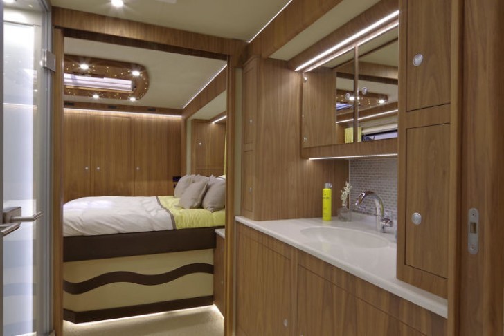 Ce camping-car de rêve présente une salle de bain à côté d'une chambre double.