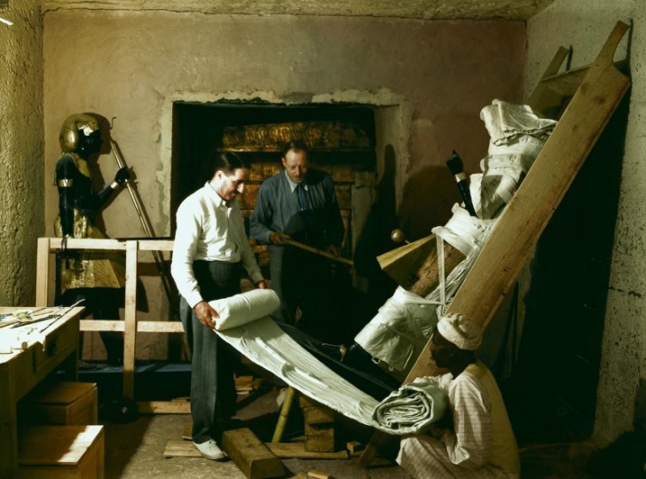 Howard Carter, Arthur Callender et un ouvrier égyptien s'occupent d'une des statues pour le transport