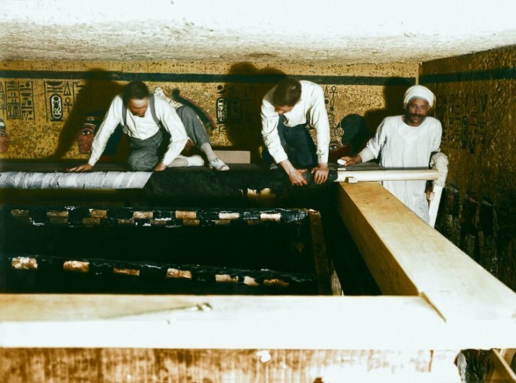 Carter, Mace et un ouvrier égyptien enveloppent soigneusement le vêtement de lin qui recouvre le deuxième sanctuaire.