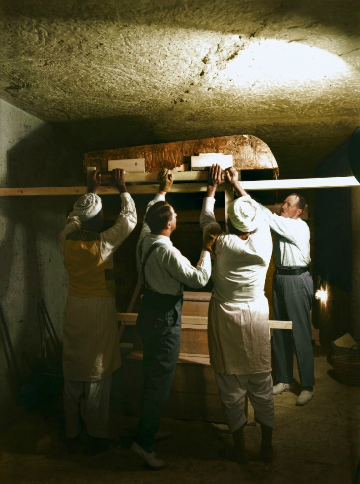 Carter, Callender et deux ouvriers égyptiens démantèlent l'un des sanctuaires dorés de la chambre sépulcrale.
