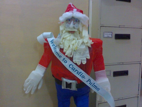 A Santa Claus greets hospital staff and visitors at the entrance to a ward.