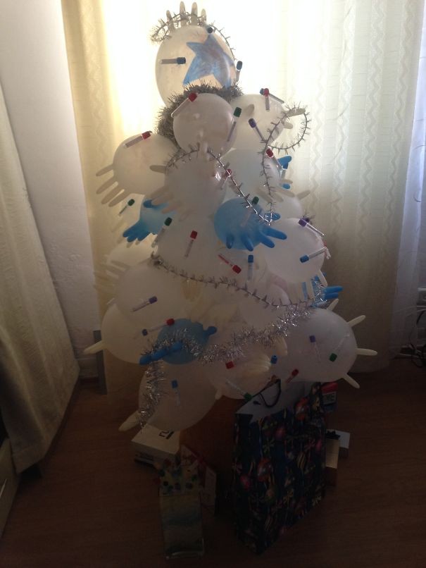 A Christmas tree decorated with medical gloves and syringes.