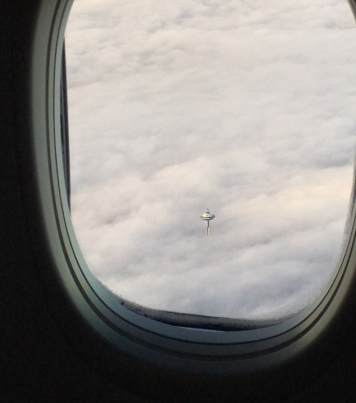 De Space Needle toren van Seattle steekt boven de wolken uit en lijkt een ruimteschip.