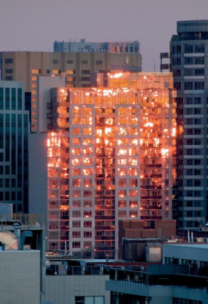 Het lijkt of het gebouw in brand staat, maar in werkelijkheid weerspiegelt het de zonsondergang