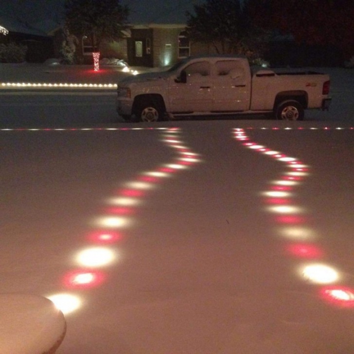 The Christmas lights are still on and functioning perfectly under a sheet of ice.
