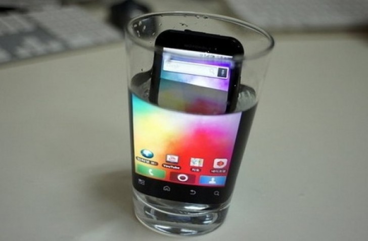 Das Smartphone in ein Glas Wasser stellen, damit sich der Bildschirm vergrößert.