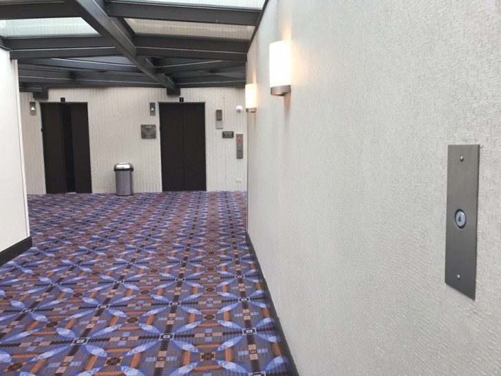 Un bouton est installé le long du couloir de cet hôtel à quelques mètres de l'ascenseur pour garder les portes ouvertes le temps d'y accéder.