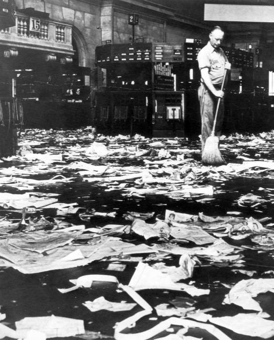 Un uomo delle pulizie spazza il pavimento della Borsa di New York, il giorno del crollo di Wall Street, 1929.