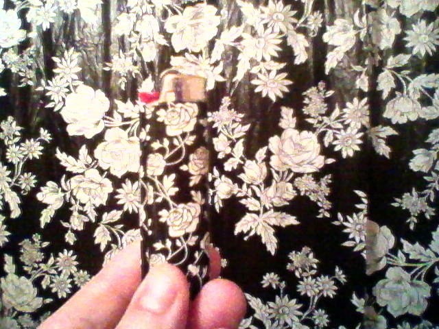 A cigarette lighter and the floral print of the curtains.