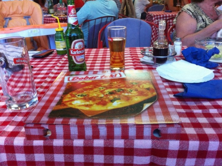 There's a pizza box carton on the tablecloth, do you see it?