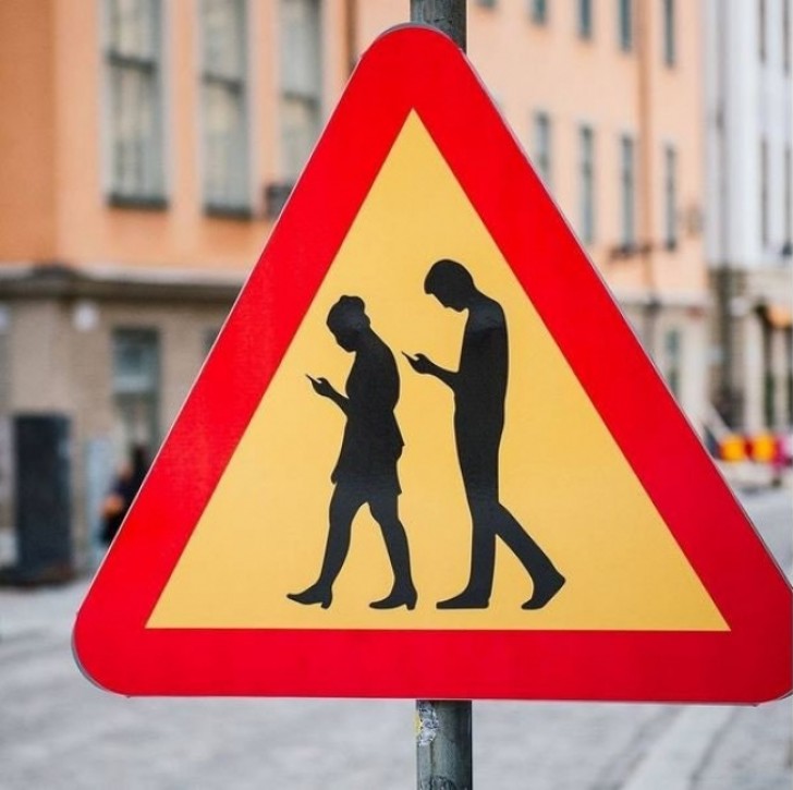 3 - A street sign in Sweden warns motorists to watch out for pedestrians who are totally absorbed in using their smartphone!