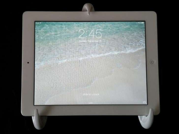 16. By attaching three simple adhesive hooks to a wall, you can create a tablet stand!