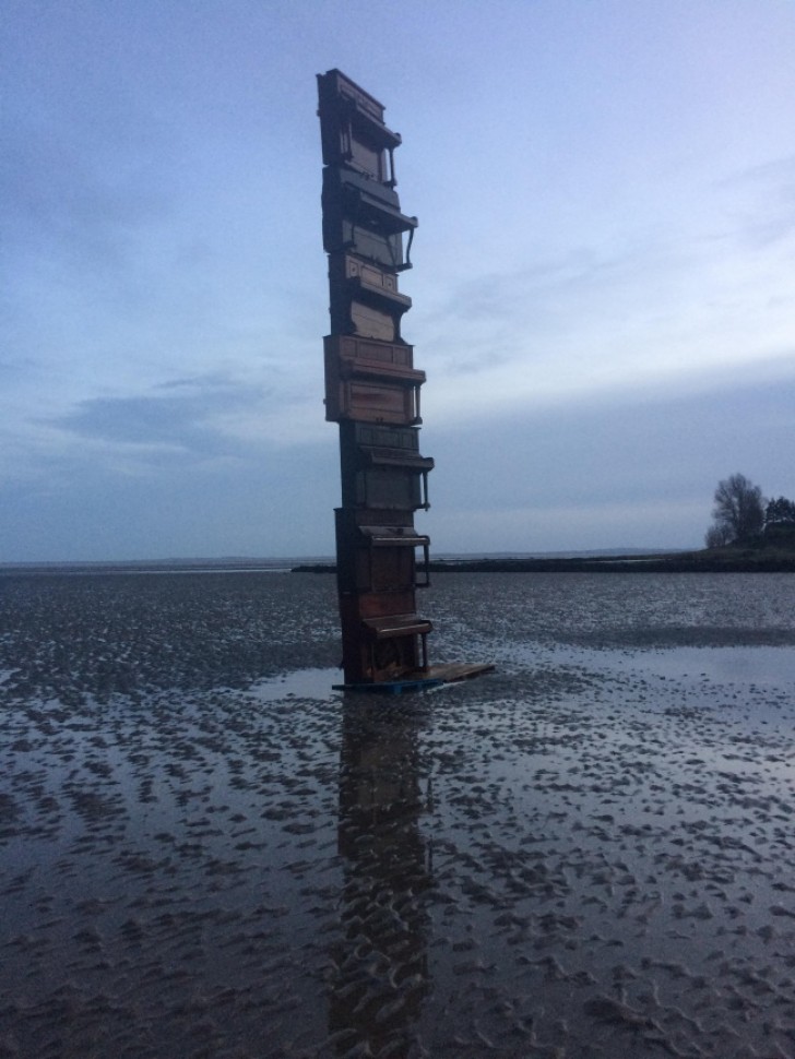 18. Pianos stacked on a beach during low tide. Why not?