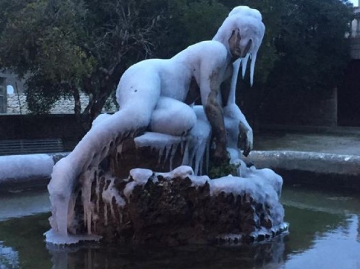 Das Wasser des Brunnen gefriert und bedeckt die Statue mit Eis