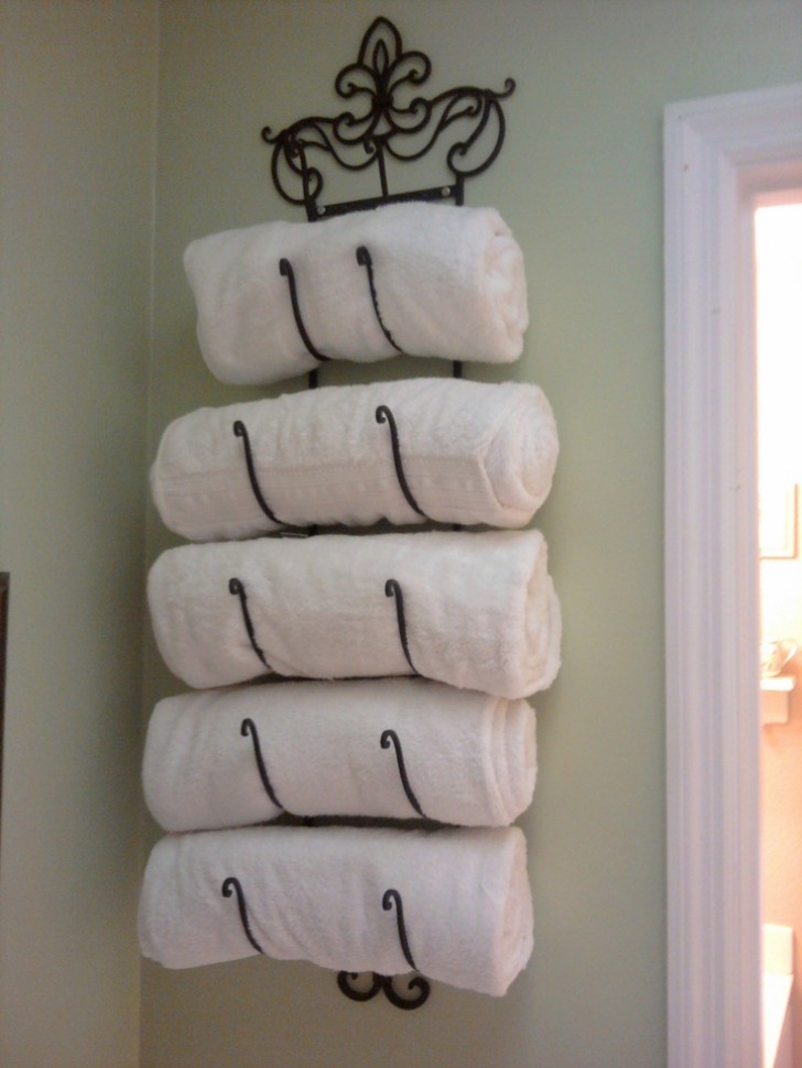 A nice way to arrange towels in the bathroom? Try using a wall mounted wine bottle rack!
