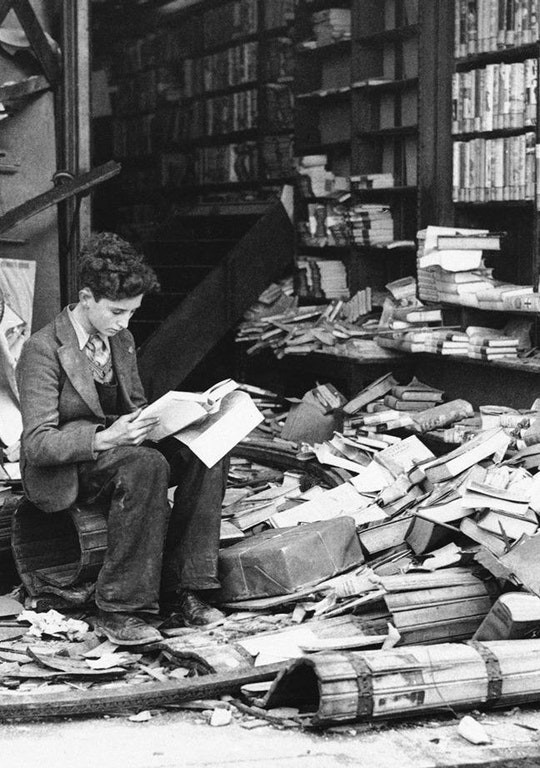 Ein Mädchen liest ein Buch in den Resten einer Londoner Bibliothek nach einem Luftangriff 1940