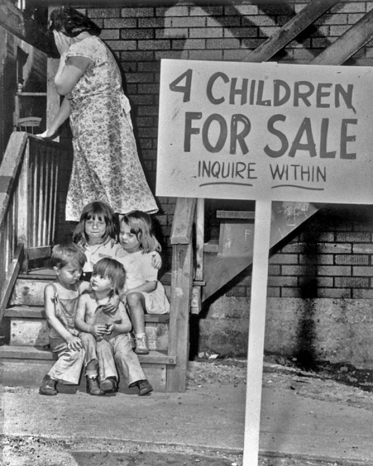 8. Een vrouw bedekt haar gezicht terwijl er een foto van haar wordt genomen als ze naast haar kinderen die ze te koop heeft gezet.