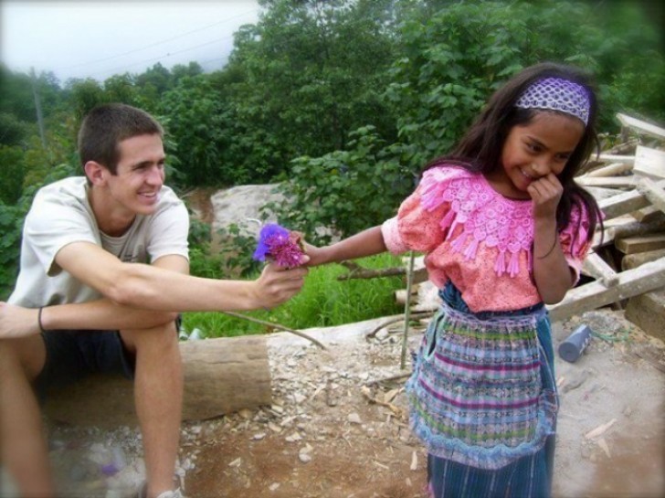 7. Ein schüchternes Mädchen bekommt eine Blume von einem Touristen in Guatemala.