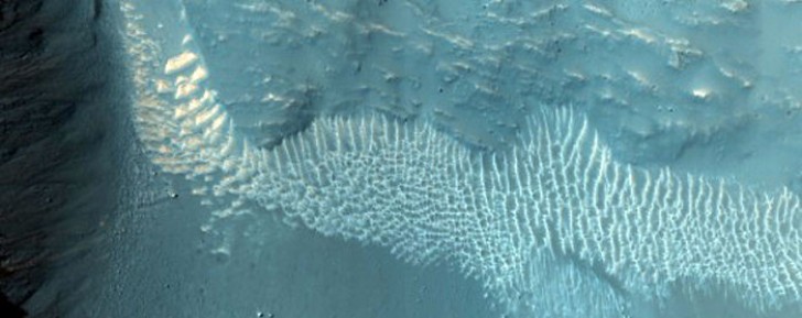 12. Un cratere ben preservato e lungo 2 km nella valle marziana di Tithonium Chasma.