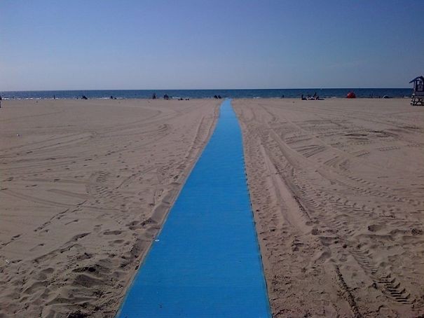 Een zeer lange loopbrug met toegang tot het strand voor kinderwagens en rolstoelen.