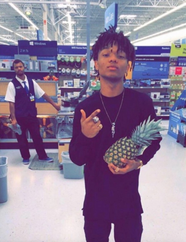 Posing with a pineapple --- and for some reason, he thinks it's cool.