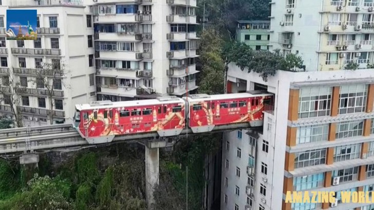 Ein Zug, der durch besetzte Häuser fährt, Chongqing, China.
