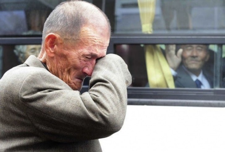 8. De man op de achtergrond keert terug naar Noord-Korea en groet zijn broer die in Zuid-Korea woont na een tijdelijke ontmoeting van familieleden