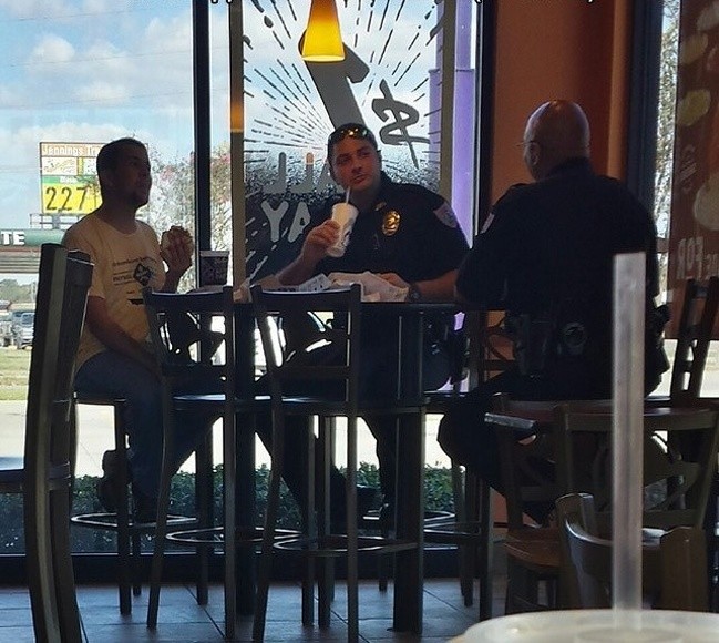 Deux policiers offrent le déjeuner à un homme souffrant de handicap mental.
