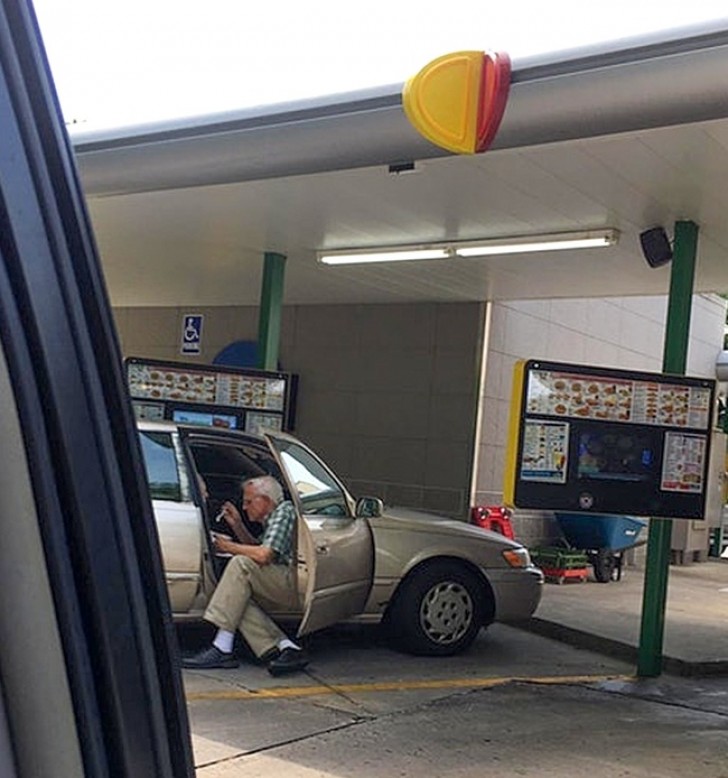 Un señor anciano ayuda a su mujer a comer un helado.