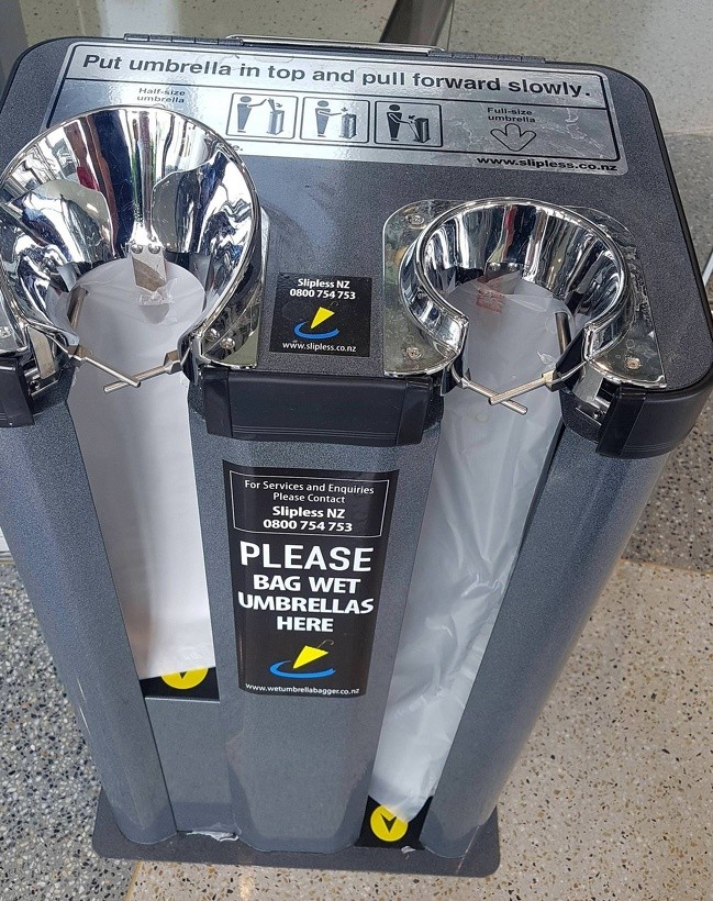 Machinery for bagging wet umbrellas, at the entrance of a supermarket.