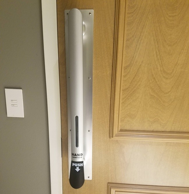 A door handle with a built-in hand sanitizer dispenser.