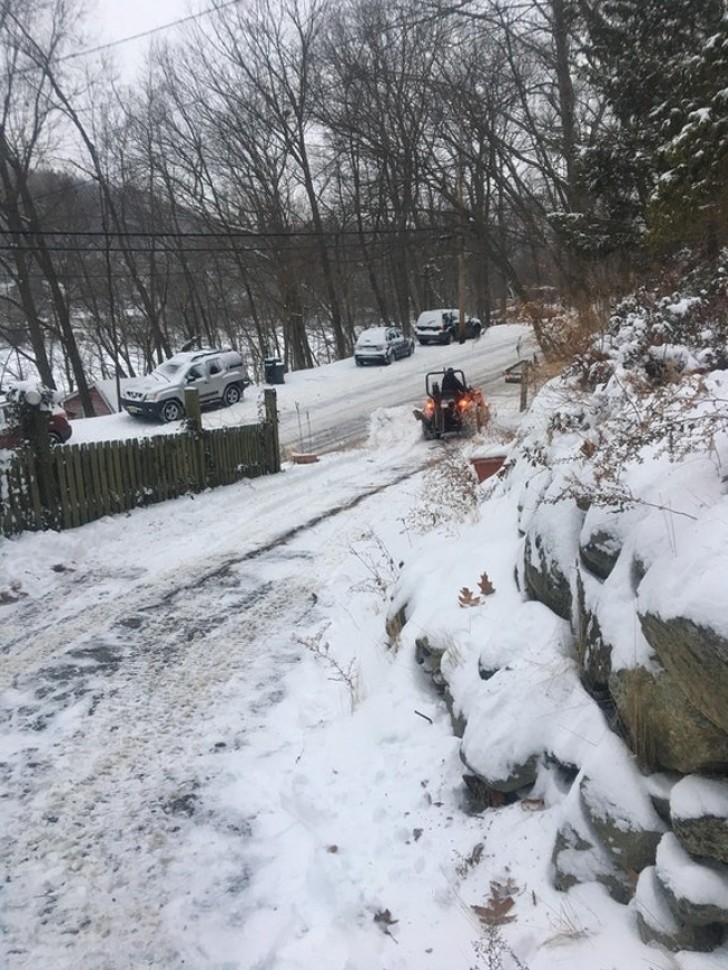 Um vizinho tira a neve do caminho para que todos possam passar.