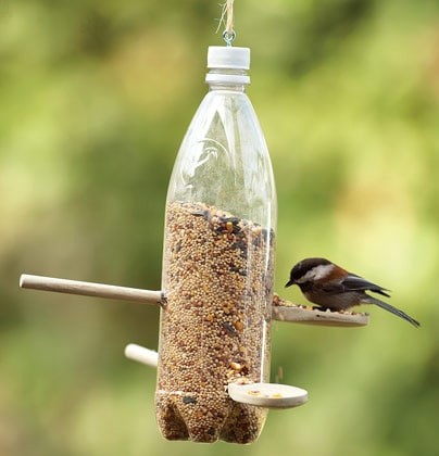 9. Make a bird feeder with a plastic bottle and a couple of wooden spoons