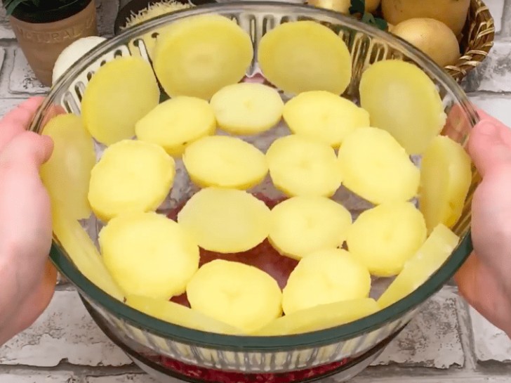 2. Boil the potatoes until they are lightly softened (you should be able to cut them into slices without breaking them). Next, let them cool then place them sliced ​on the bottom and sides of a baking dish.