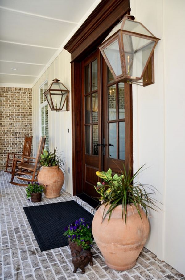 If the entrance is spacious, fill it with large objects. In this case, outdoor lanterns and large terracotta vases were used.