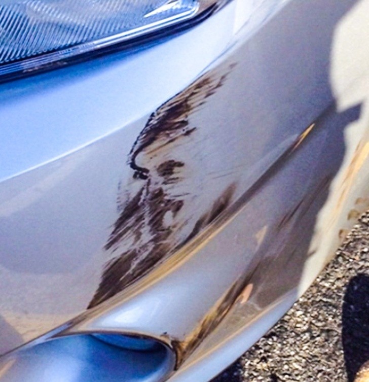 22. Une rayure sur la voiture dessine un visage sur le pare-chocs endommagé.