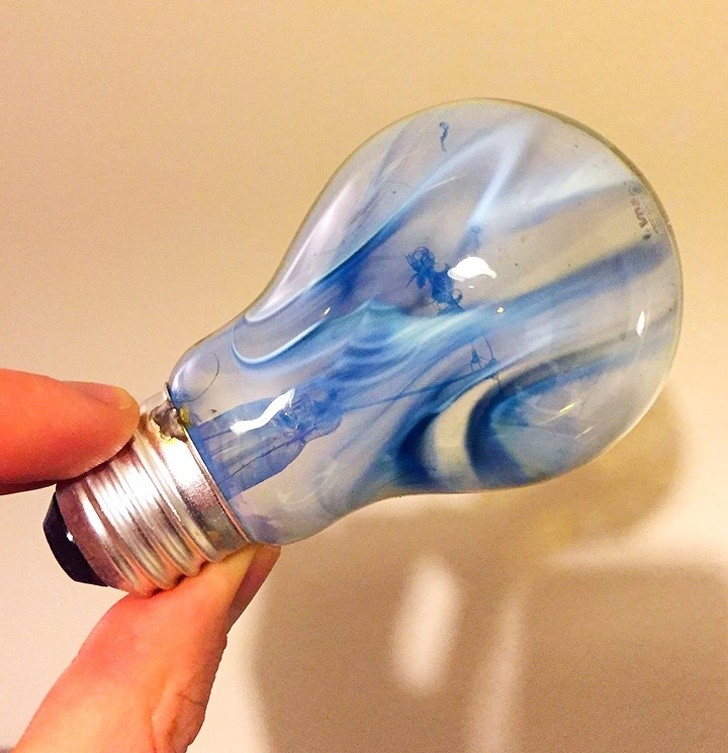 23. Une ampoule brûlée est teintée de traînées de diverses nuances de bleu.