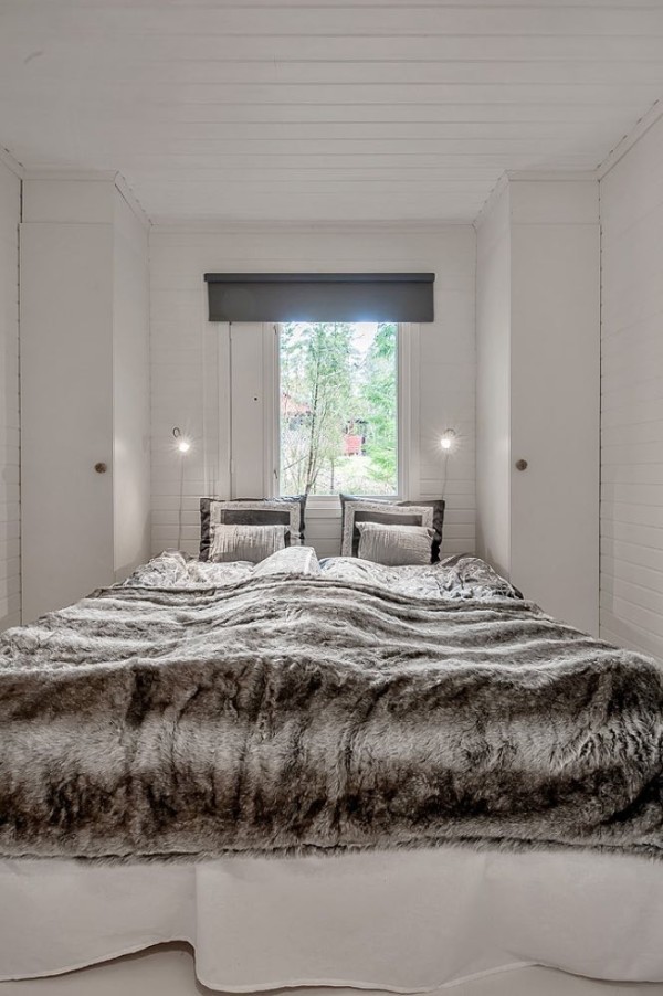 The bedroom is illuminated by the window at the head of the bed, and is enriched with elegant fabrics and a rather distinctive furry bed cover, with its various tones of pearl gray that contribute to the restful atmosphere.