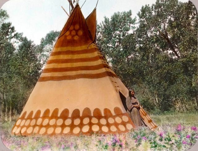 Una donna della tribù dei Piedi Neri fotografata davanti al suo tepee - Inizi del 1900.