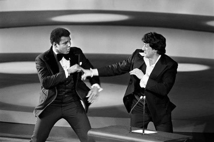 Sylvester Stallone doet alsof hij samen vecht met Muhammad Ali bij de Oscars in 1976.