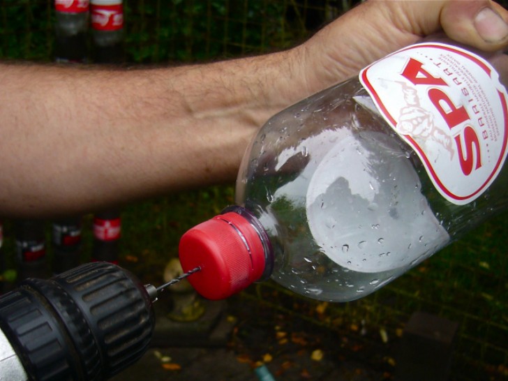 9. L'ultima bottiglia che andrete a utilizzare farà da serbatoio d'acqua: lasciate il tappo ma foratelo al centro.
