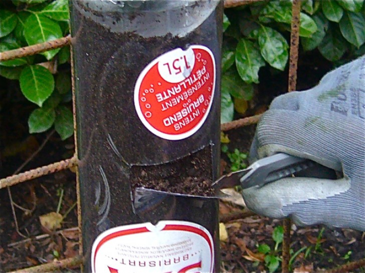 12. A l'aide d'un cutter, créez une ouverture dans les bouteilles pleines de terre.