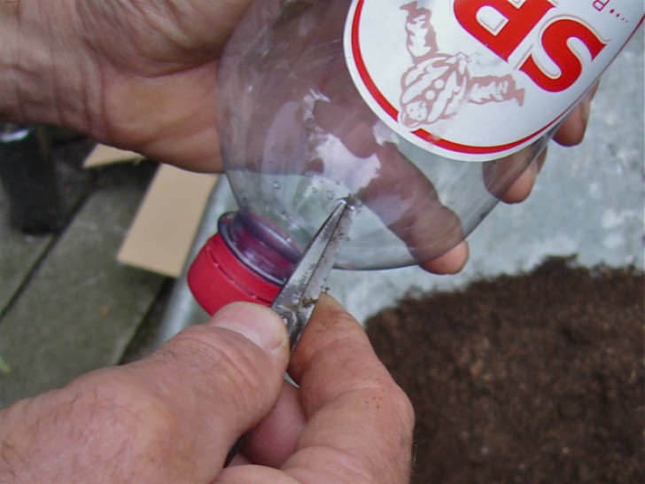 3. Make two holes measuring about 2 - 4 in (5-10 cm) away from the cap (here we see the first hole to be made).