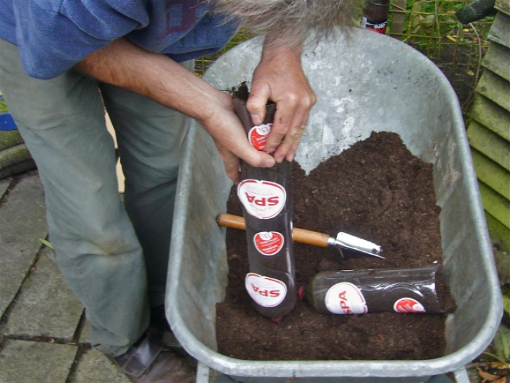 6. Remova a a base como você fez na primeira garrafa e encha todas eles de terra. Empilhe uma sobre as outra.