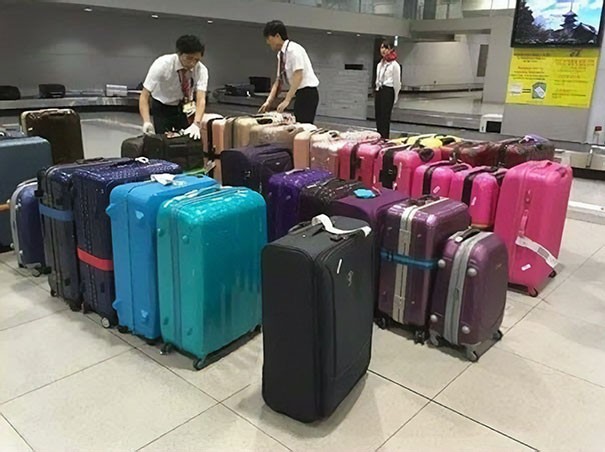Gli addetti dell'aeroporto ordinano le valigie in base al colore. 