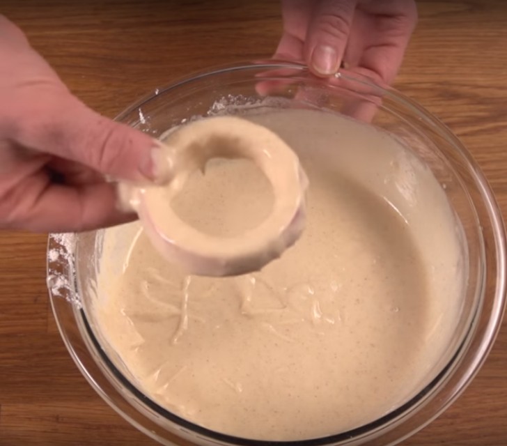 After dipping the apple rings into the batter, fry them in the hot oil, turning them on the other side as soon as the batter becomes golden brown.