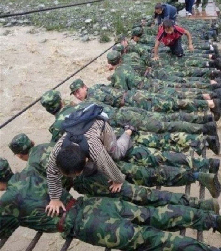 7. Estos soldados han creado un puente con sus cuerpos durante un aluvion